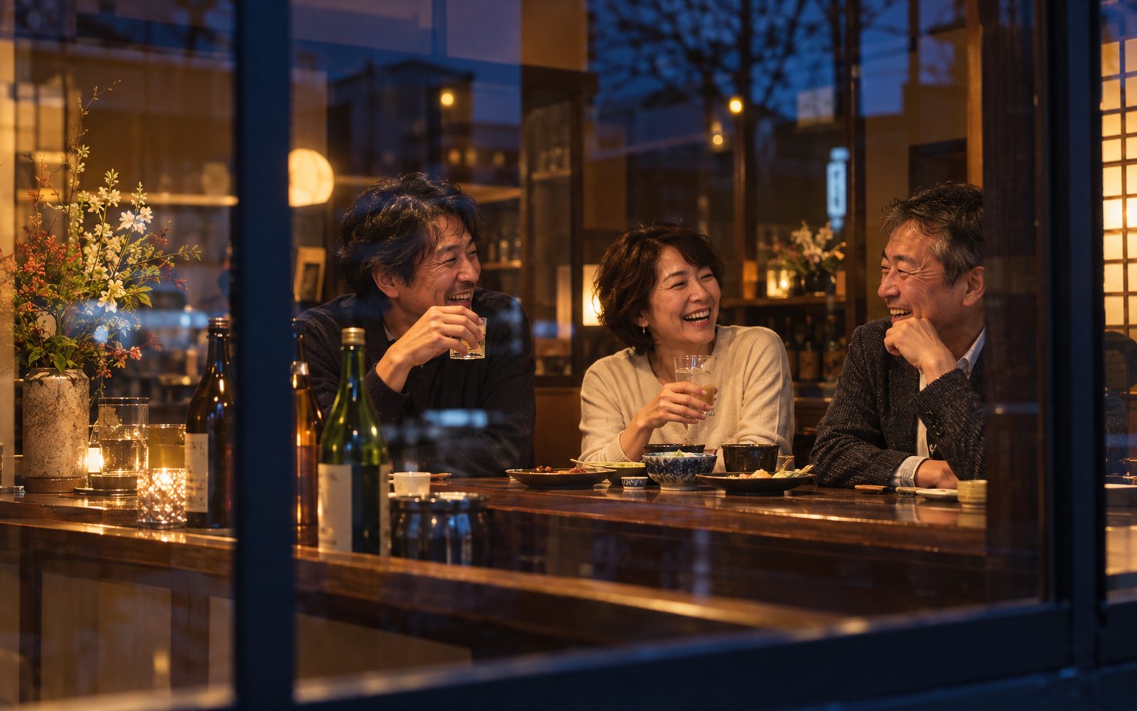 夜の店内で笑顔で語らうお客様のイメージ